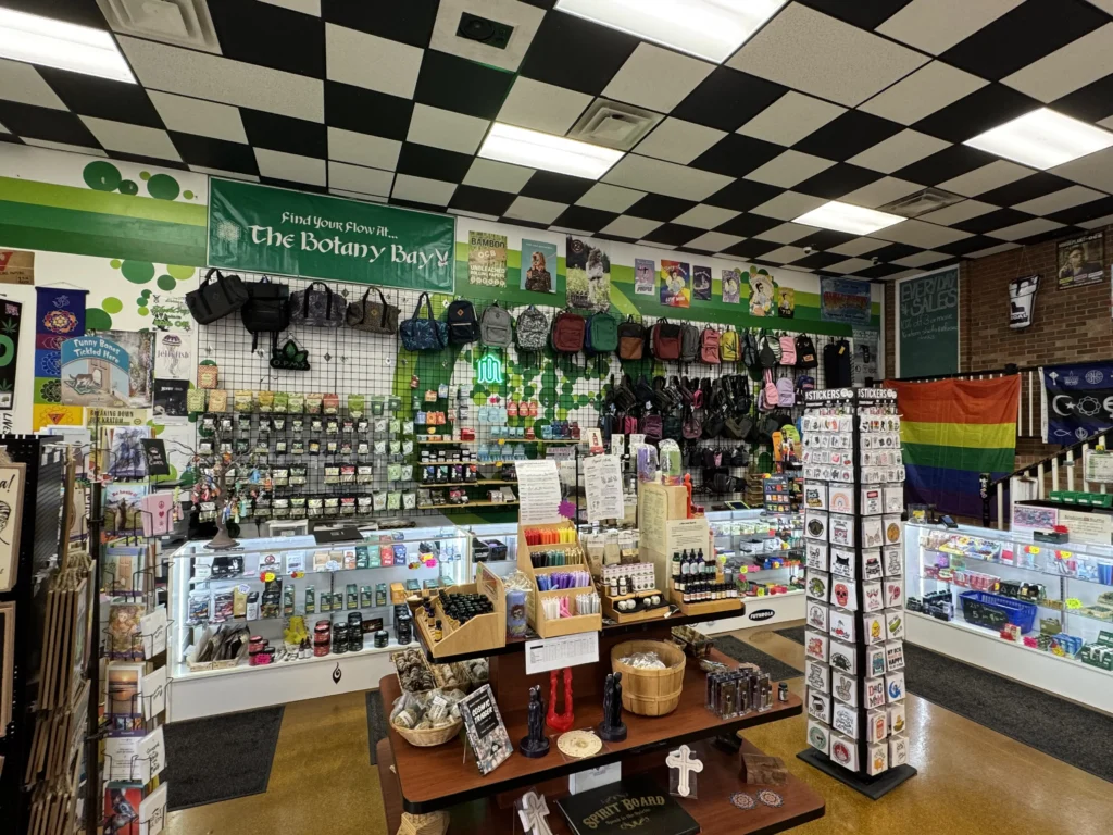 Front counter of The Botany Bay Richmond KY smoke shop with displays of stickers, incense, candles, glass pipes, vape supplies, and smoking accessories.