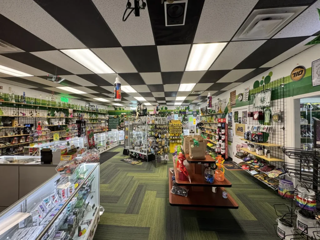 Interior of The Botany Bay Richmond KY head shop with glass bongs, hand pipes, vapes, rolling papers, and smoking accessories displayed on shelves and cases.